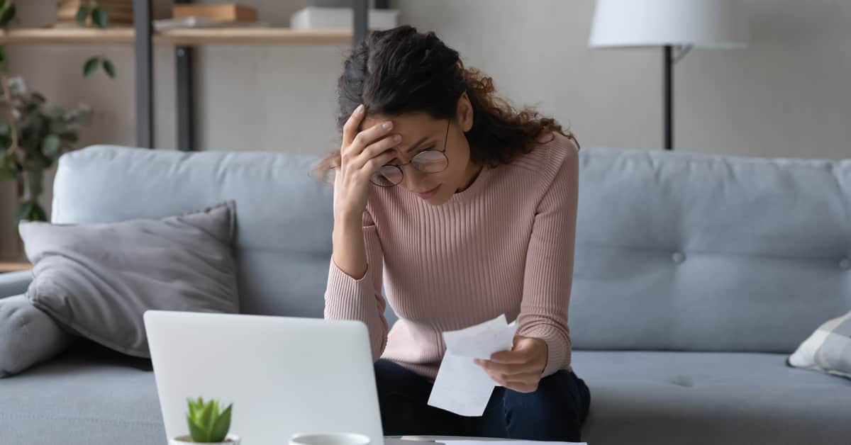 woman-exhibiting-the-signs-of-employee-financial-stress-while-working-on-laptop